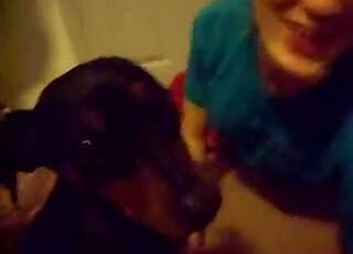La fille en t-shirt bleu est prête à branler un chien et à se faire baiser aussi