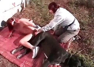 Une salope de zoo chevauche le pénis impressionnant d'un gros chien en plein air